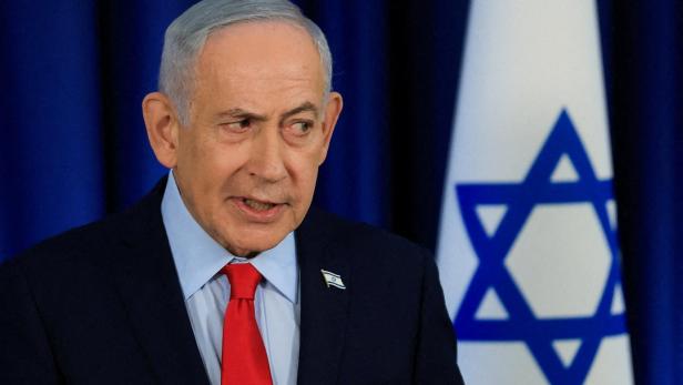 Benjamin Netanjahu spricht vor einer israelischen Flagge.