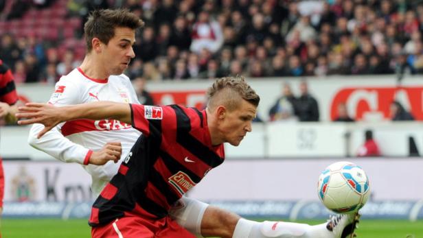 Zwei Fußballspieler kämpfen um den Ball während eines Spiels.