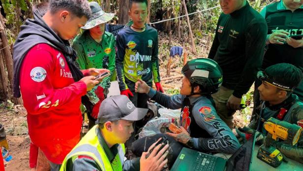 Members of a rescue team work to save seven people trapped in a cave, at a location given as Xaisomboun Province