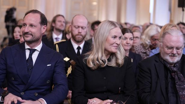 Kronprinz Haakon und Kronprinzessin Mette-Marit sitzen mit anderen Gästen bei einer Veranstaltung.