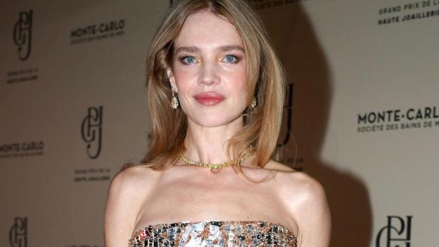 Natalia Vodianova trägt ein glitzerndes, trägerloses Kleid und eine weiße Clutch.
