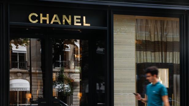 Ein Mann geht an einem Chanel-Geschäft mit goldener Aufschrift vorbei.