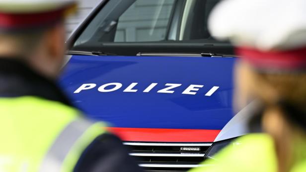 Polizisten vor Polizeiauto