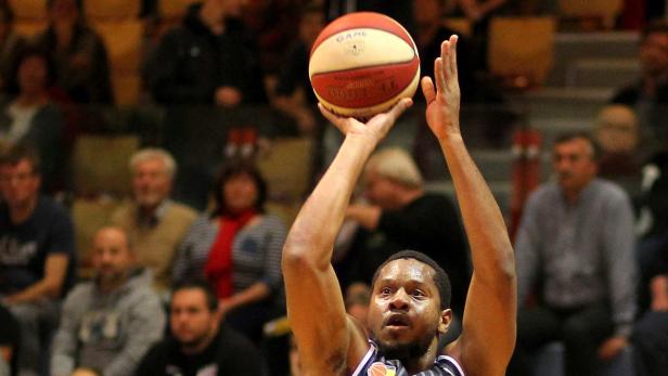 Ein Basketballspieler zielt auf den Korb.