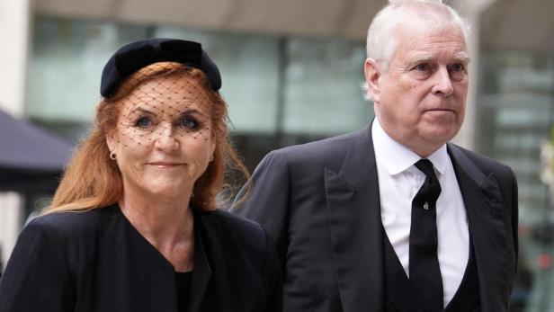 Sarah Ferguson und Prinz Andrew in dunkler Kleidung, die Herzogin mit Schleier, blicken ernst.