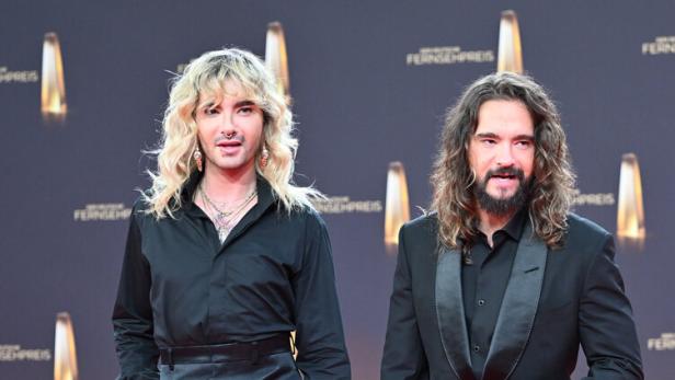 Die Brüder Kaulitz posieren in schwarzen Outfits auf dem roten Teppich.
