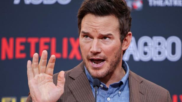 Chris Pratt spricht vor einem Hintergrund mit Logos von Netflix und AGBO.