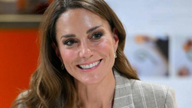 Prinzessin Kate lächelt in einem gestreiften Blazer und mit verschränkten Händen.