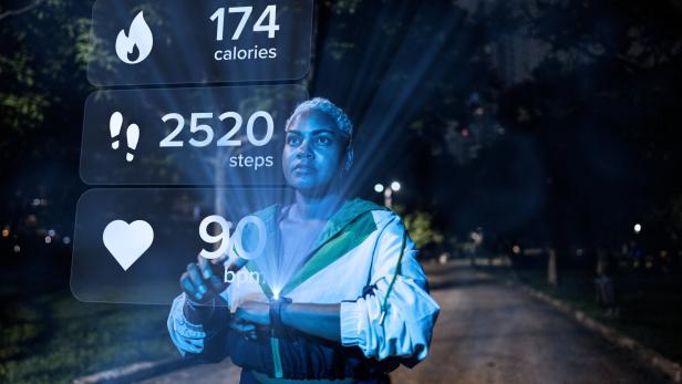 Young woman with smart watch looking at sports infographic hologram at the public park