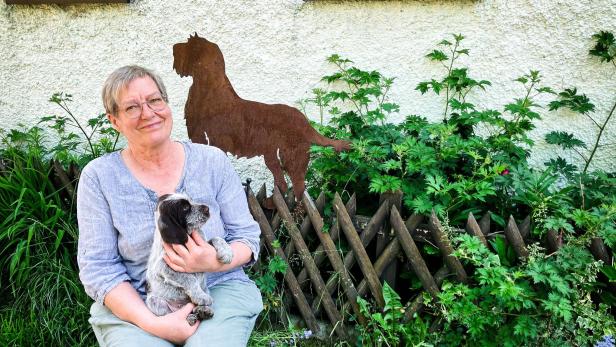 Die Patientin mit Welpen im Schoß im Garten
