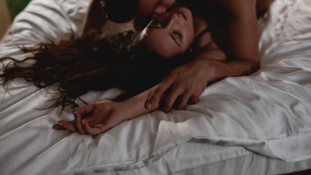 I need your love. Cropped shot of young couple making love in the bed. Passionate man gently kissing beautiful woman on neck with desire