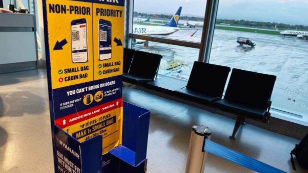 Ryanair signage at Manchester Airport waiting area with planes outside window