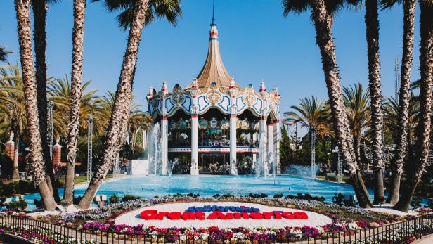 Ein Karussell mit Springbrunnen und Palmen im California's Great America Park.