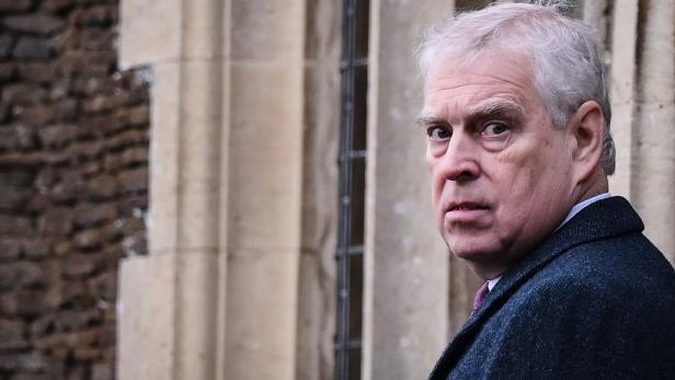 Ex-Prinz Andrew blickt über seine Schulter vor einem Gebäude mit Steinmauer.