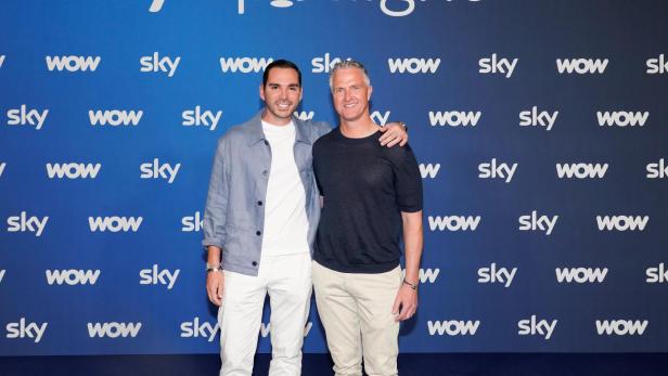 Ralf Schumacher und Étienne Bousquet-Cassagne posieren gemeinsam vor einer Sky-Spotlight-Wand bei einer öffentlichen Veranstaltung.