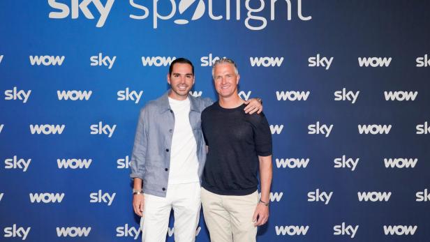 Ralf Schumacher und Étienne Bousquet-Cassagne posieren gemeinsam vor einer Sky-Spotlight-Wand bei einer öffentlichen Veranstaltung.