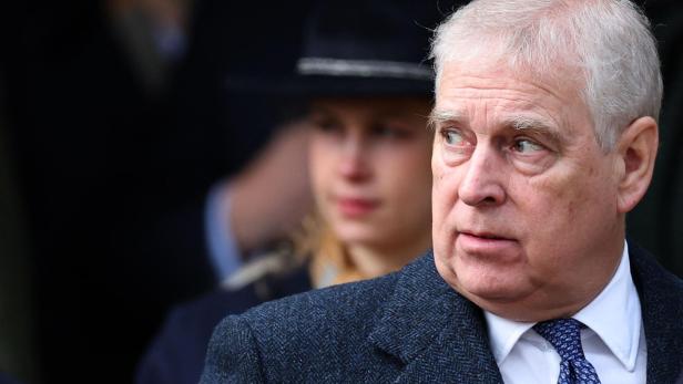 Andrew Mountbatten-Windsor blickt mit grauem Haar und blau gemusterter Krawatte zur Seite.
