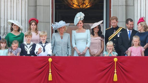 Auf einem Balkon stehen Mitglieder der königlichen Familie, darunter Kate, Meghan und Harry.