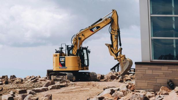 Baufahrzeug auf einer Baustelle vor einem Wohnhaus