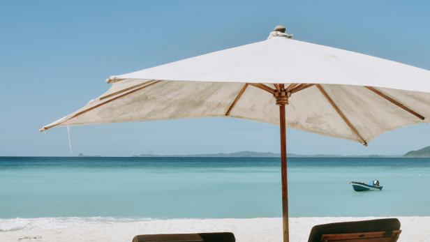 Liegen am Strand unter einem Sonnenschirm 