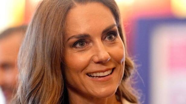 Prinzessin Kate blickt zur Seite. Sie trägt ein rotes Kleid mit weißen Punkten.