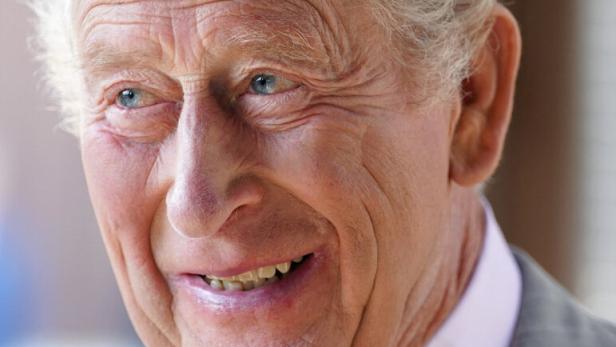 König Charles III. blickt lächelnd zur Seite