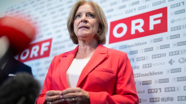 Ingrid Thurnher in einem roten Blazer spricht vor einer Pressewand mit dem Logo des ORF.