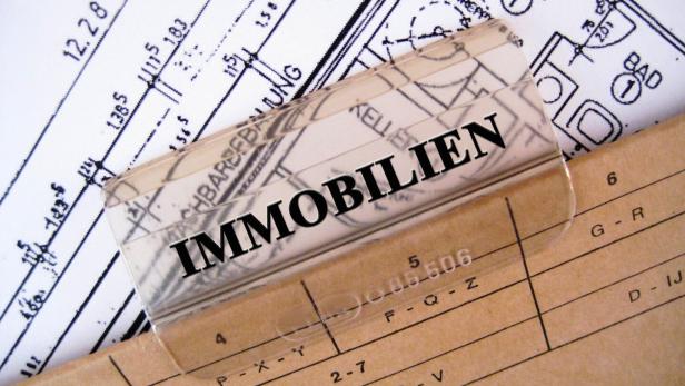 Eine Mappe, beschriftet mit dem Wort "Immobilien", in der Pläne und Grundrisse gesammelt wurden. 