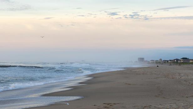 Leerer Sandstrand mit Wellen und leichtem Nebel am frühen Morgen in Wildwood, New Jersey.