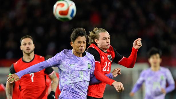 Ein Spieler aus Südkorea und ein österreichischer Nationalspieler kämpfen im Zweikampf um einen hohen Ball.
