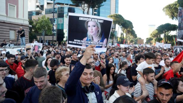Eine Person hält bei einer Demonstration ein Schild mit einem Foto von Ivanka Trump und der Aufschrift „American Nepo Baby“ in die Höhe.