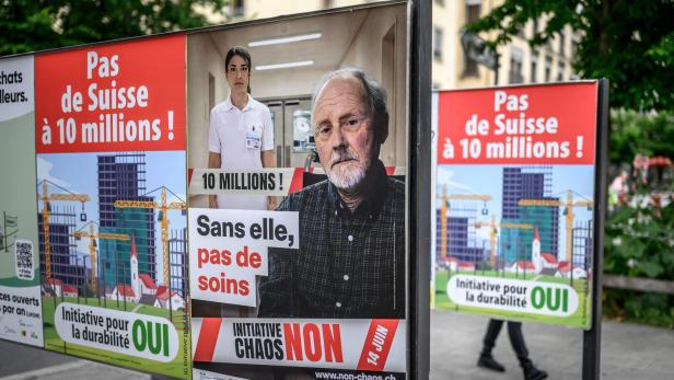 Politische Plakate gegen eine 10-Millionen-Schweiz zeigen einen älteren Mann und eine Pflegekraft mit dem Slogan „Sans elle, pas de soins“.