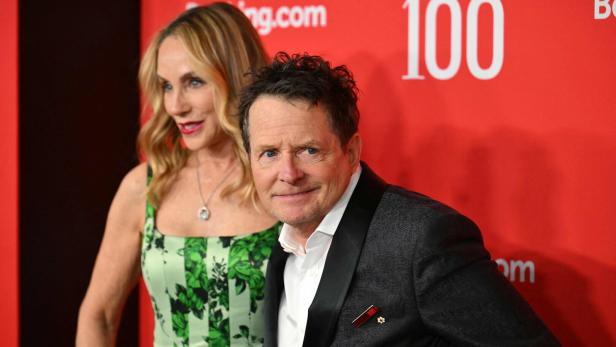 Michael J. Fox und Tracy Pollan posieren vor einer roten Wand bei der TIME 100 Gala.