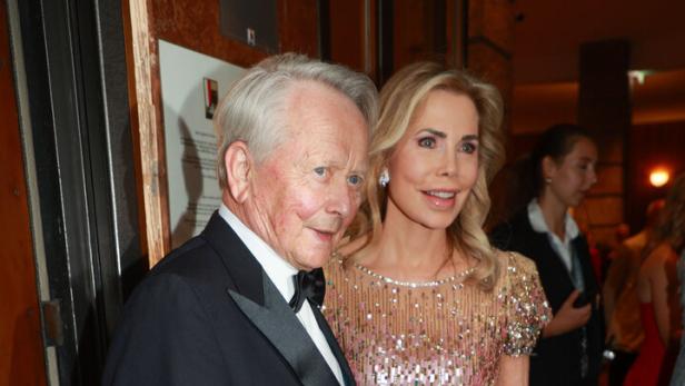 Wolfgang Porsche im Smoking und Gabriele Porsche in einem glitzernden Abendkleid stehen nebeneinander bei einer festlichen Veranstaltung.