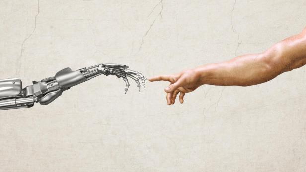 Ein menschlicher Arm und eine Roboterhand berühren sich fast mit ausgestrecktem Zeigefinger vor hellem Hintergrund.