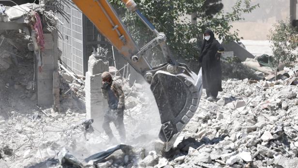 A woman stands among the rubble of her house, which was damaged in a U.S. and Israeli strike in March, in Tehran