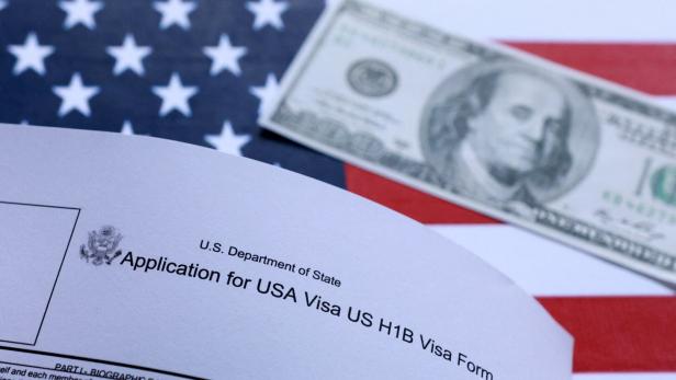 U.S. flag, mock passport, 100 dollar banknote and H-1B visa application form