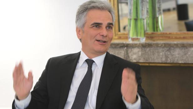 Ein Mann im Anzug gestikuliert mit beiden Händen.
