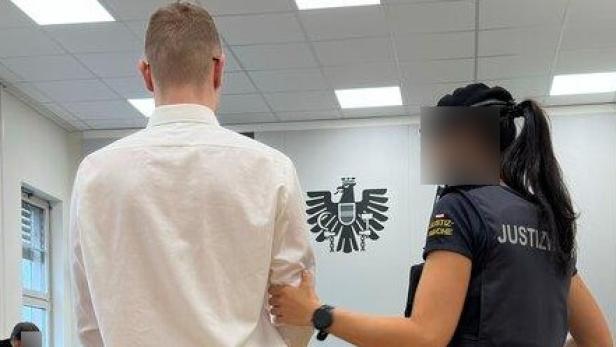 Ein Angeklagter und eine Justizwachebeamtin im Gerichtssaal