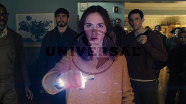 Emily Blunt hält einen hell leuchtenden Stab in der Hand.