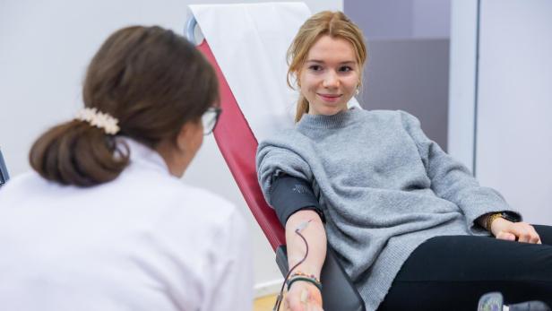 Eine junge Frau spendet Blut unter Aufsicht einer Mitarbeiterin des Roten Kreuzes in Niederösterreich.