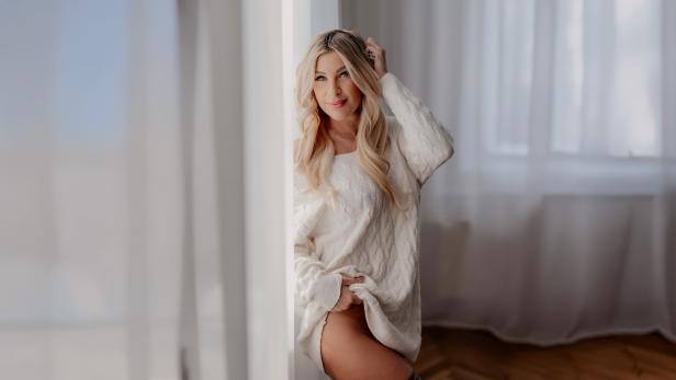 Eine blonde Frau in einem weißen Raum 