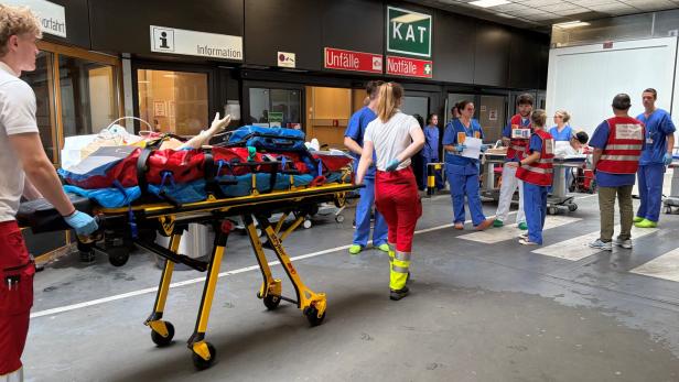 Eine Simulationspuppe wird von Notfallsanitätern in die Unfallambulanz transportiert