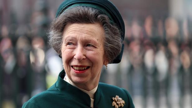 Prinzessin Anne lächelt in einem dunkelgrünen Kostüm mit passendem Hut und einer auffälligen Brosche.