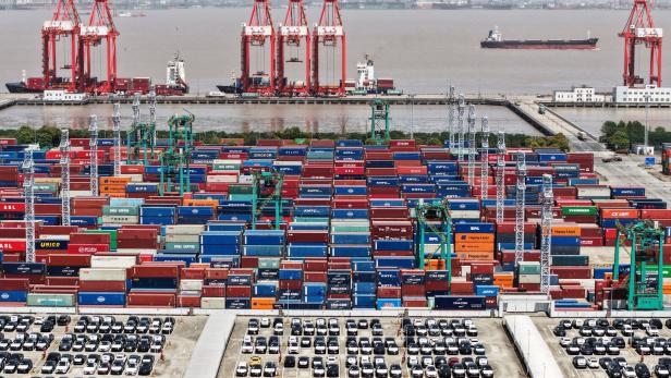 FILE PHOTO: Drone view shows electric vehicles (EV) for export and containers sitting at a port in Shanghai