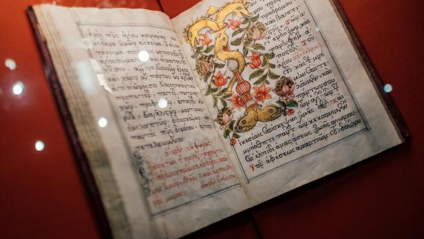 Geöffnetes altes Buch mit handgeschriebenem Text und farbiger floraler Illustration auf der rechten Seite