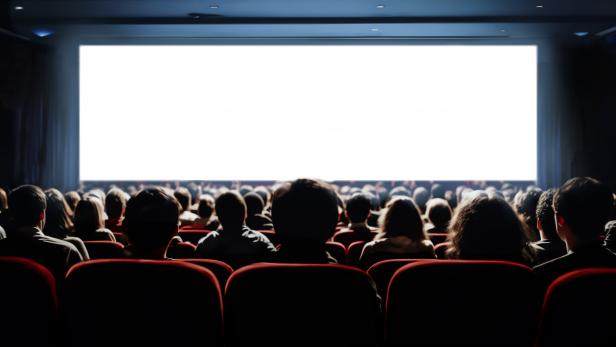 People in the cinema hall with empty white screen.