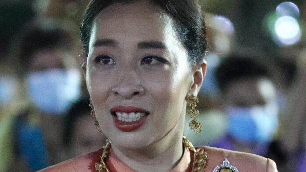 Prinzessin Bajrakitiyabha von Thailand trägt ein pfirsichfarbenes Kleid mit roten Mustern und eine goldene Halskette.