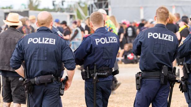 Drei Uniformierte bewachen ein Festival