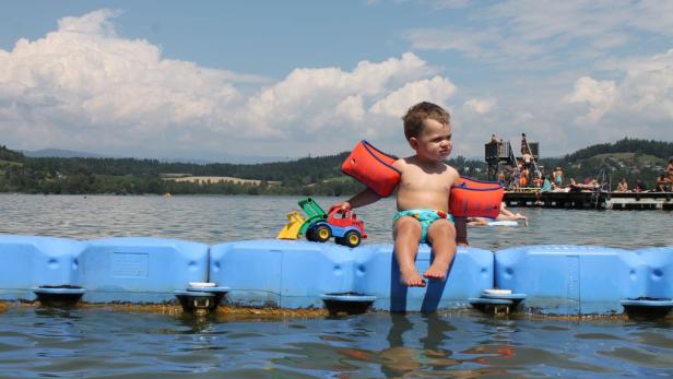 Der Längsee ist weitgehend naturbelassen. Und 75 Hektar Fläche sind genug, um auf der Begrenzung des Kinderbereiches zu posieren.